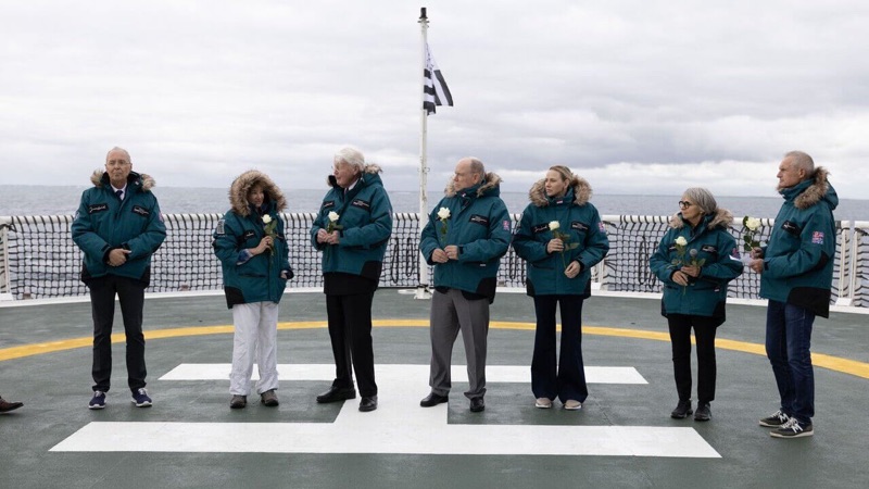 Deltakerne i seremonien samlet på dekk med hvite roser
