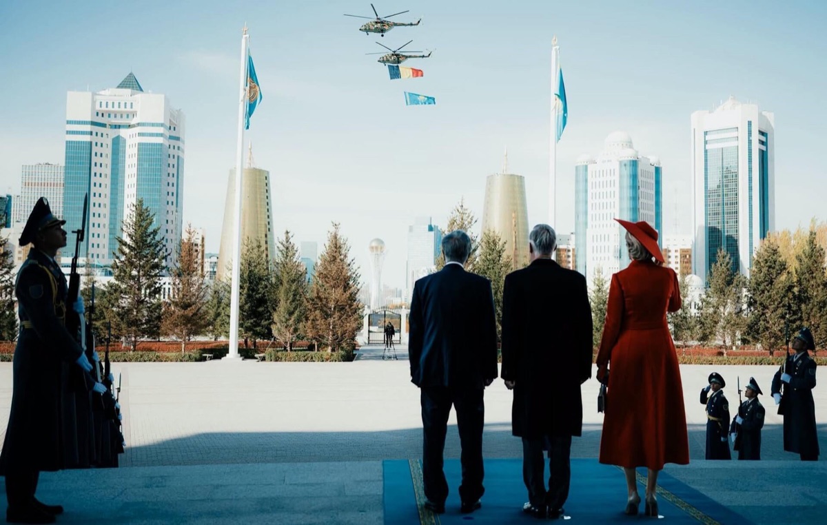 Helicopters carrying the Belgian and Kazakh flags fly in over Astana as the royal couple and the President look up