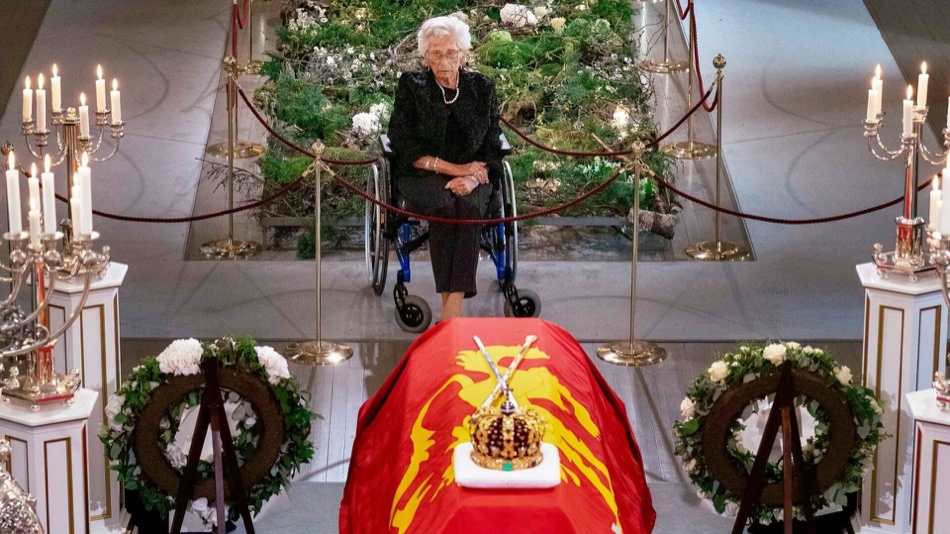 Princess Astrid sits in a wheelchair in the Palace Chapel in front of King Harald