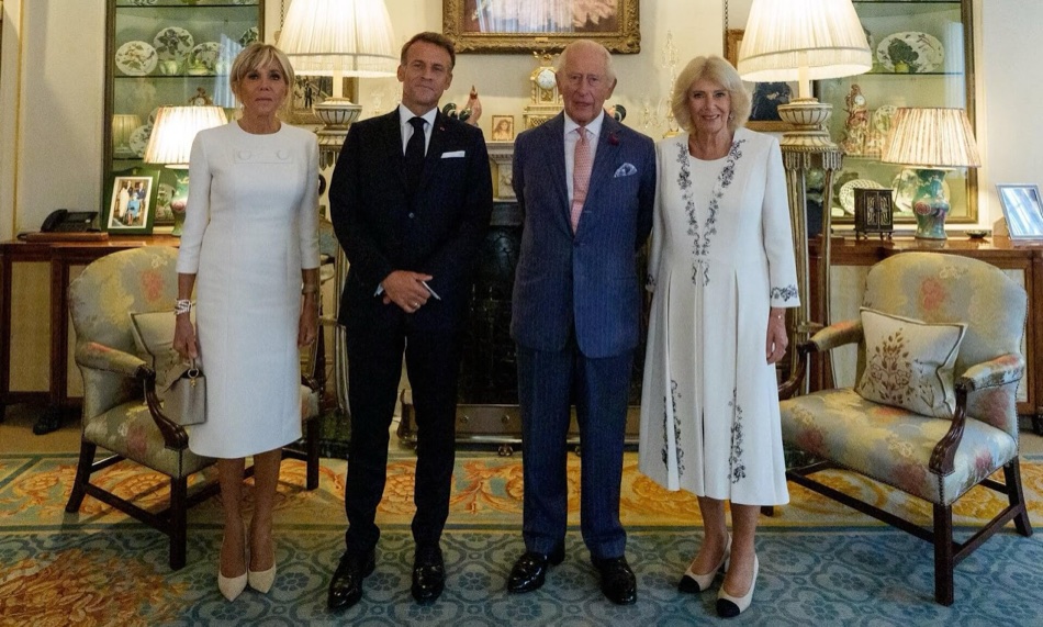 Brigitte Macron, President Macron, King Charles and Queen Camilla standing in a drawing room with armchairs, lamps and porcelain cabinets