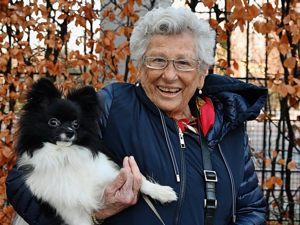Princess Astrid sits in a chair with her dog Tarzan beside her