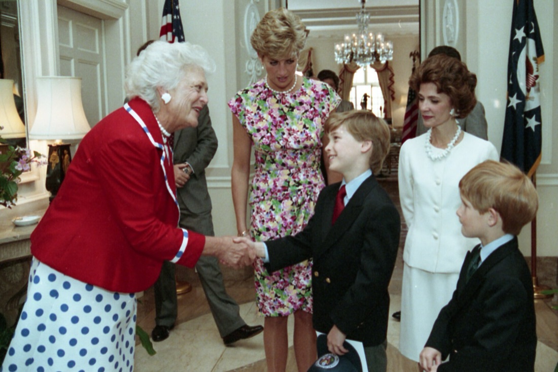 William og Harry i dress hilser på en eldre kvinne i rød jakke, med Diana ved siden av