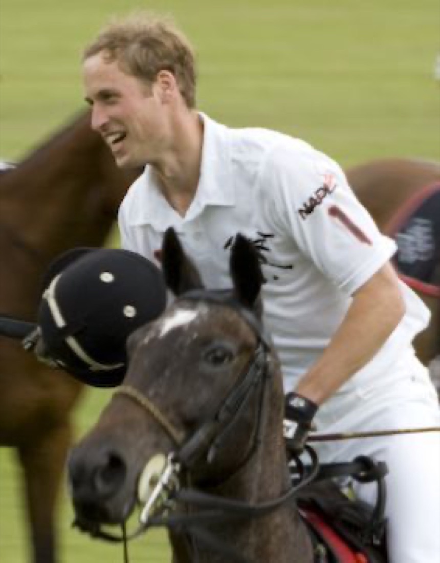 William i hvit poloskjorte på hesteryggen, smilende