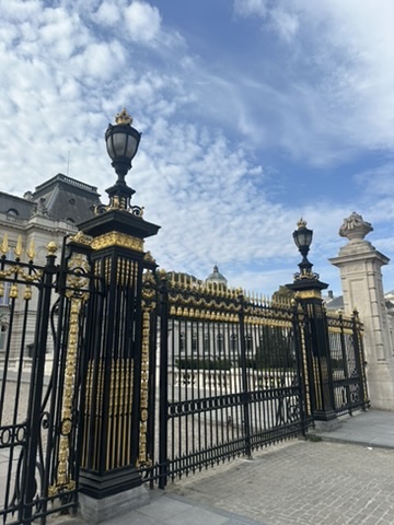 The black and gilded railings with crowned lamp posts around the palace grounds