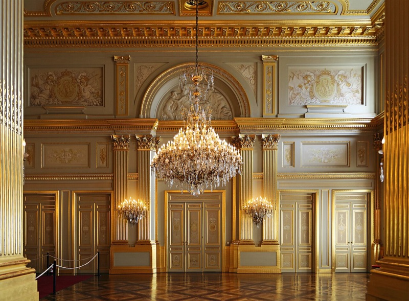 Detail of the Throne Room with gilded columns and a large crystal chandelier