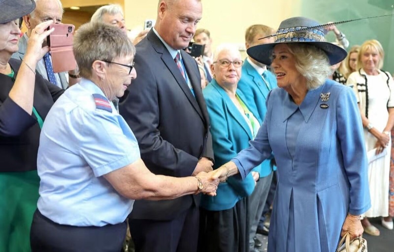 Dronning Camilla håndhilser på en frivillig fra St John Ambulance