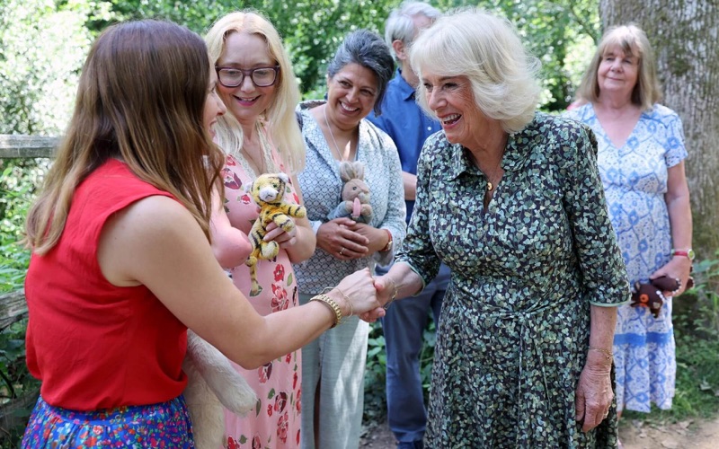 Dronning Camilla hilser på gjester med kosedyr fra barnebøkene