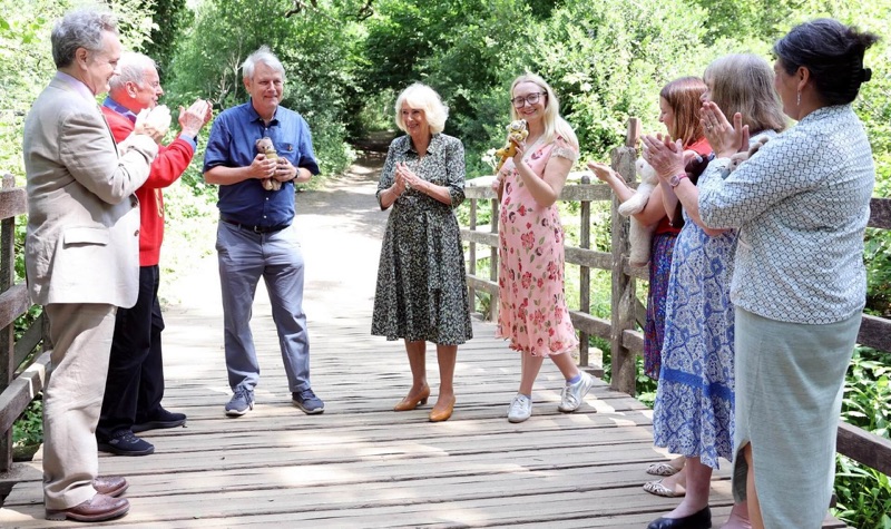 Dronning Camilla og gjestene samlet på Poohsticks Bridge