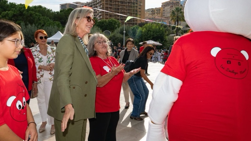 Princess Caroline walks through the event with volunteers and the head of the association