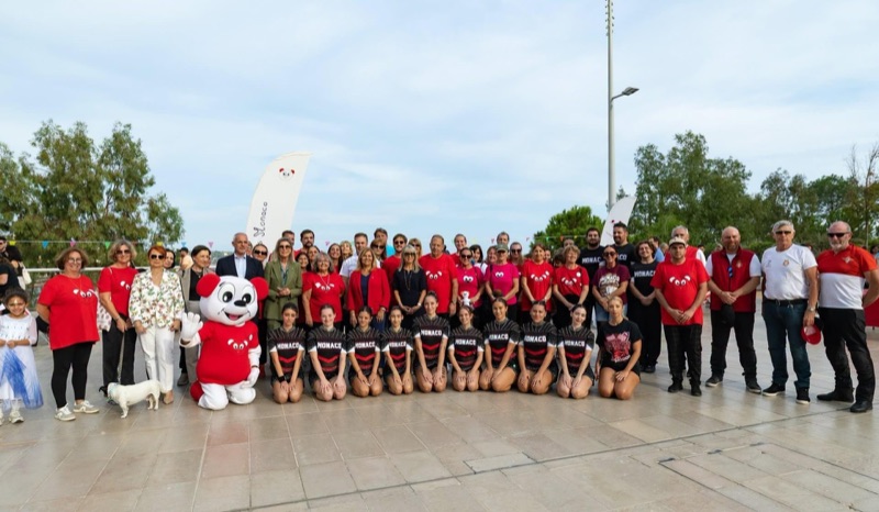 Large group photograph with Princess Caroline, volunteers in red T-shirts, the mascot and a gymnastics team from Monaco