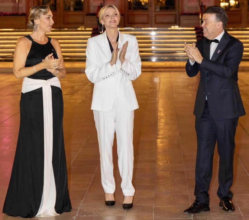 Princess Charlène applauds alongside the head of the association and a man in a dinner jacket