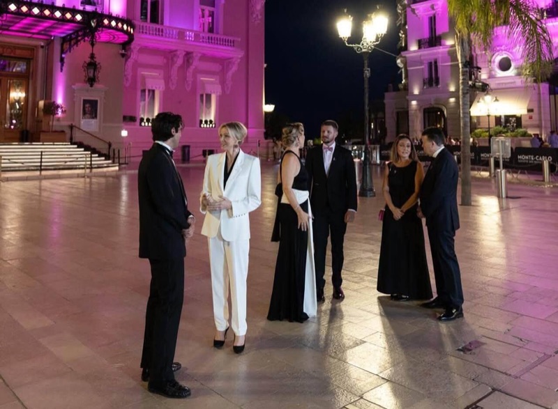 Casino Square in Monte-Carlo bathed in pink light in the evening, with the Princess and her party on the square