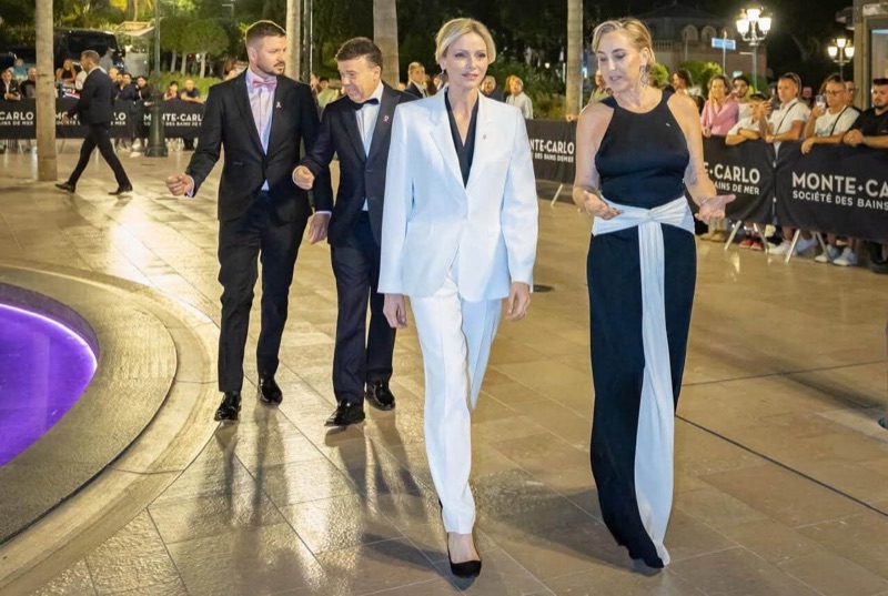 Princess Charlène walks across the square with the head of the association and the organisers