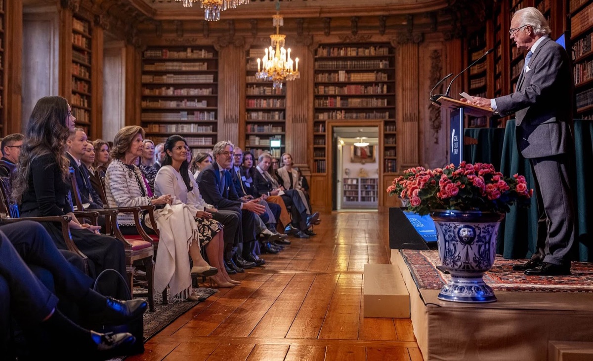 Kong Carl Gustaf står ved talerstolen i Bernadottebiblioteket foran deltakerne