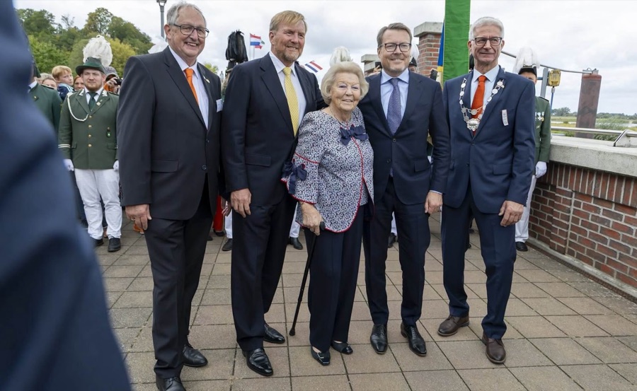 King Willem-Alexander, Princess Beatrix and Prince Constantijn pose for a group photograph with local representatives, with marksmen in green uniforms behind them