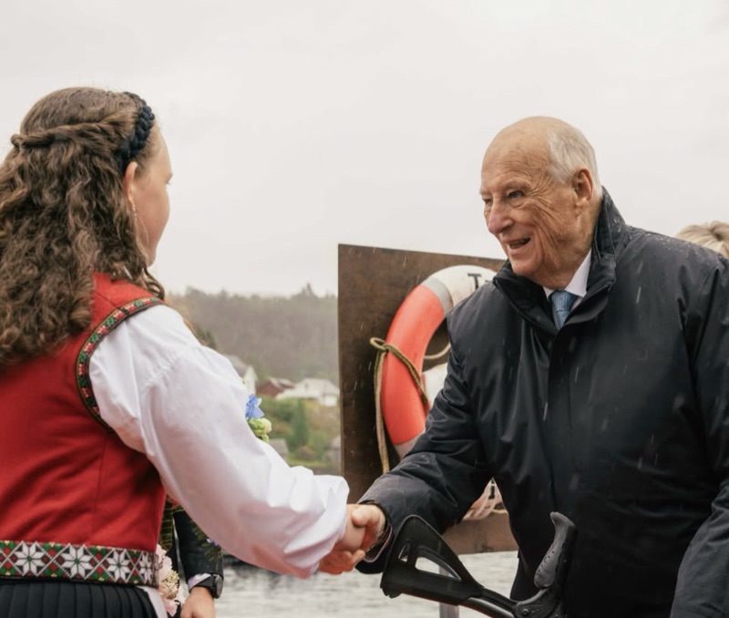 Kongen hilser på en jente i bunad