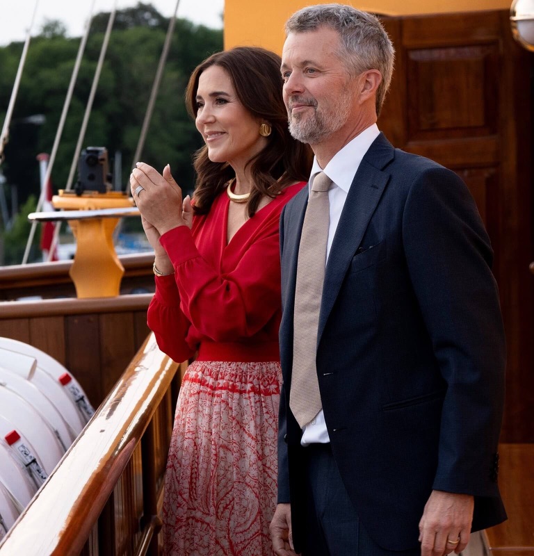 Kong Frederik og dronning Mary ser ut over havnen fra dekket