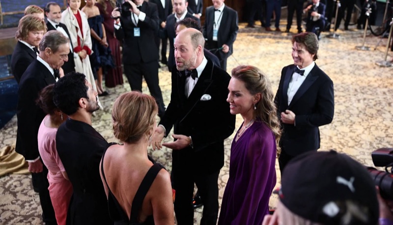 Prins William hilser på gjester inne i kinoen mens prinsesse Catherine står ved siden av ham