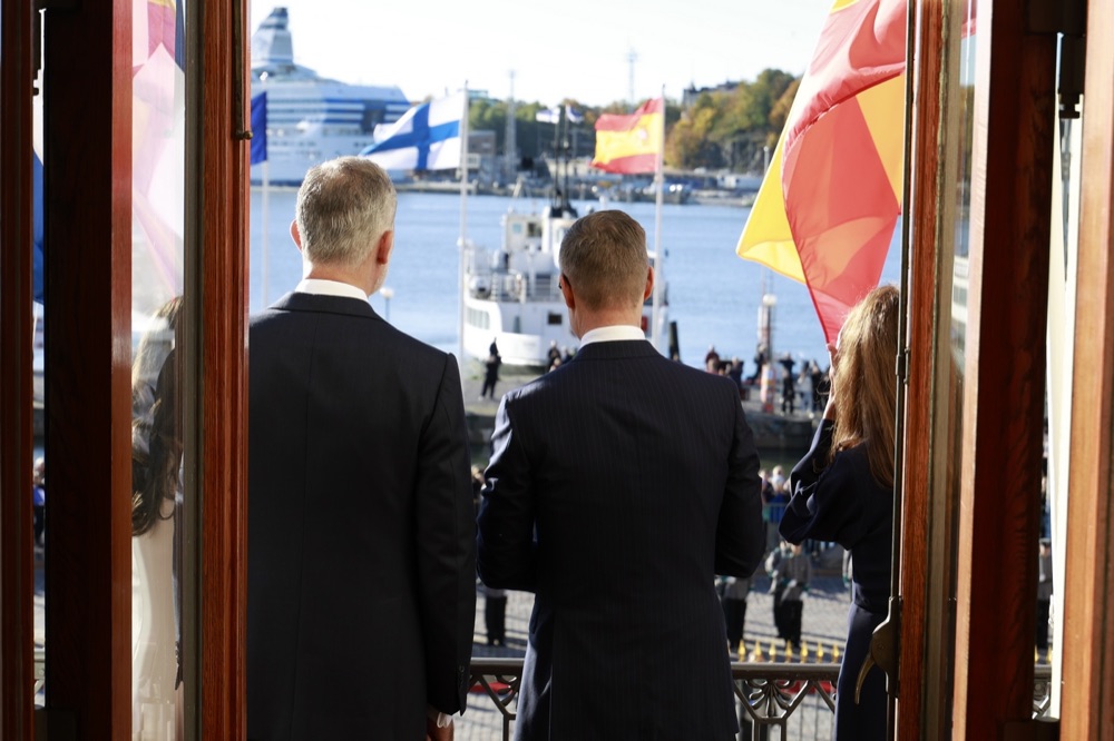Kongen og presidenten ser ut mot Salutorget og havnen fra balkongen i Presidentpalasset