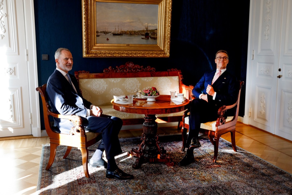 Kong Felipe og president Alexander Stubb sitter i hver sin stol i en blå salong i Presidentpalasset