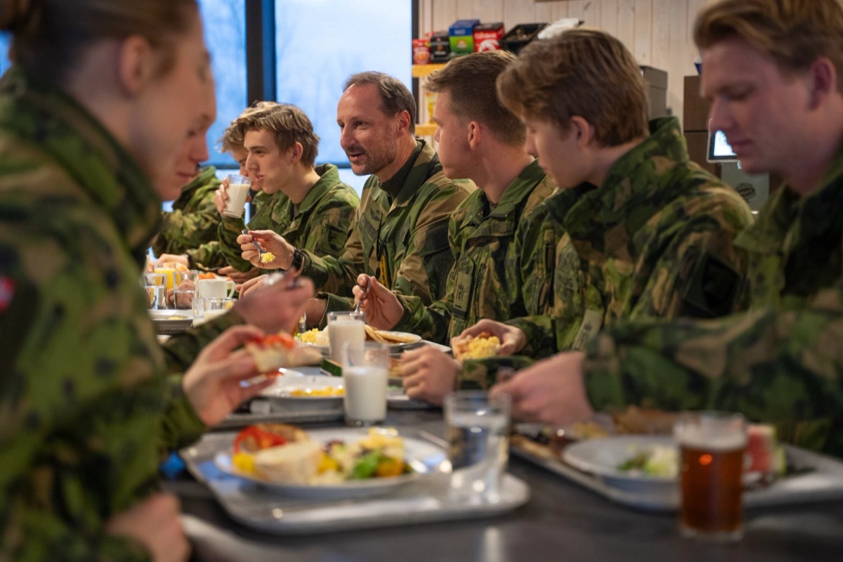 Kongen sitter til bords med soldater som spiser frokost