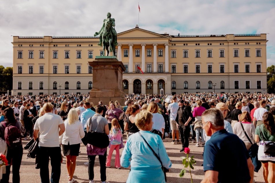 Slottsplassen full av mennesker foran Slottet og statuen av Karl Johan i solskinn
