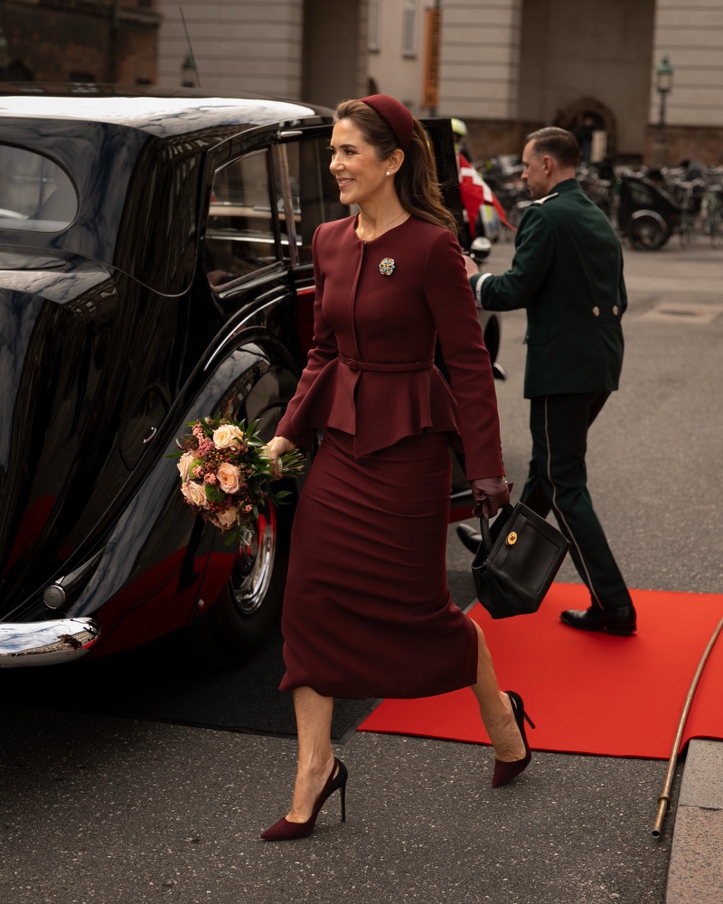 Queen Mary walks from the vintage car towards the entrance at Christiansborg holding a bouquet