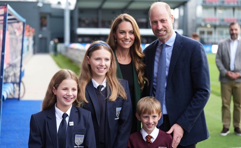Prins William og prinsesse Catherine poserer sammen med tre skolebarn i skoleuniform