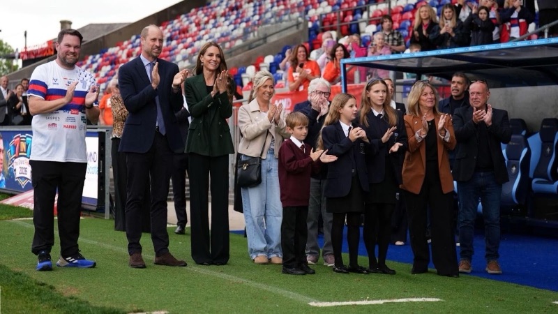 Prins William og prinsesse Catherine klapper langs banen sammen med familie og barn foran tribunen i Wakefield