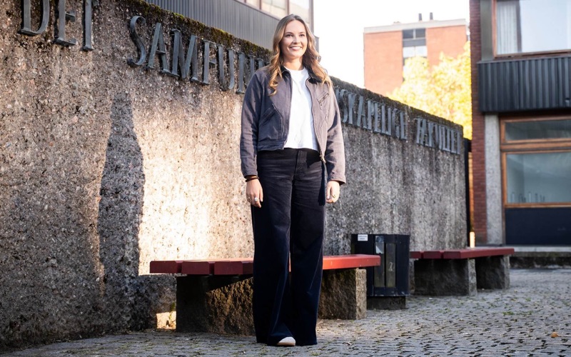 Prinsessen foran skiltet til Det samfunnsvitenskapelige fakultet