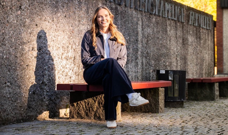 Prinsessen sitter på en rød benk foran fakultetsveggen