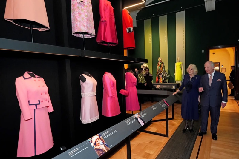 Kong Charles og dronning Camilla ser på kjoler i utstillingen