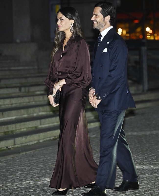 Prinsesse Sofia i mørk silkekjole og prins Carl Philip går sammen over brosteinen
