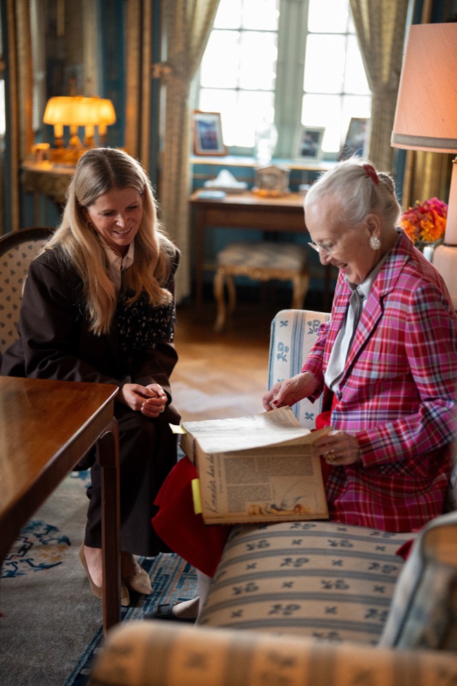 Editor-in-chief Heidi Frederikke Sigdal and Queen Margrethe leafing through bound volumes of Alt for damerne
