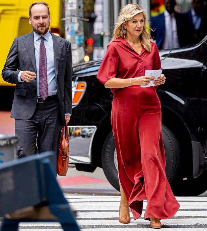 Dronning Máxima går over en gate i New York med papirer i hånden, sammen med en mann i grå dress
