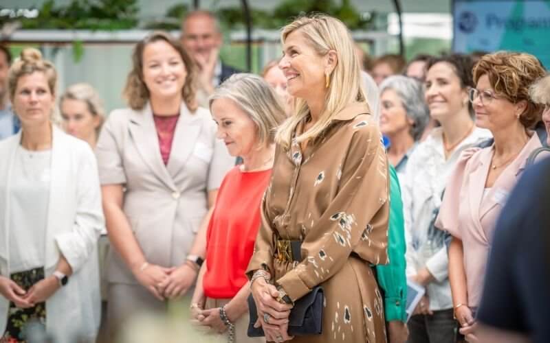 Queen Máxima smiles in a dense group of healthcare professionals during the opening