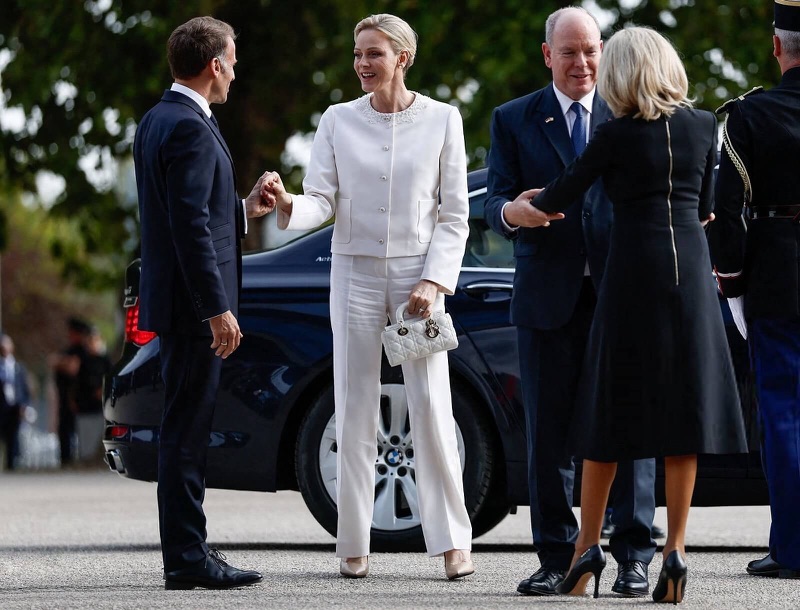 Emmanuel Macron hilser på fyrstinne Charlène ved bilen, mens fyrst Albert og Brigitte Macron står ved siden av