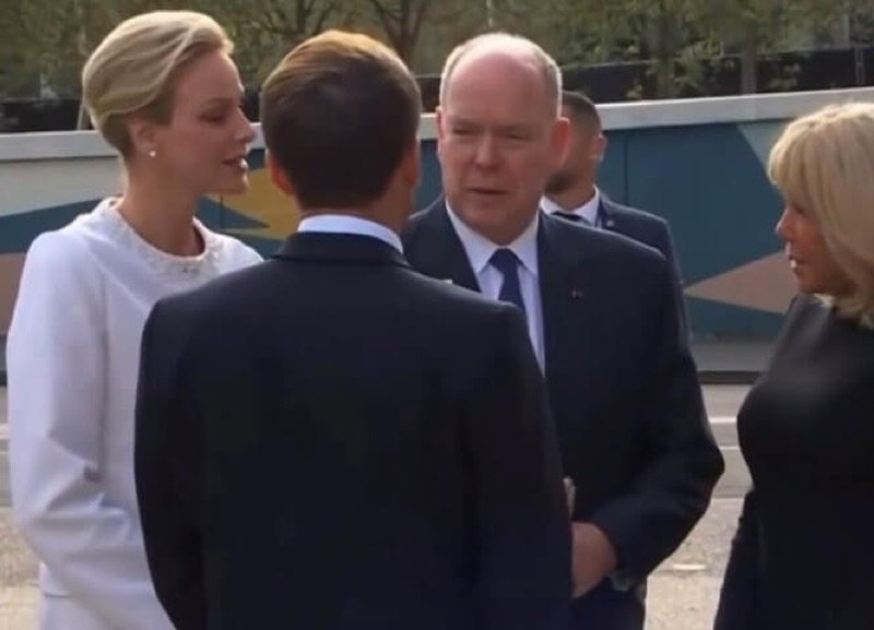 Fyrstinne Charlène og fyrst Albert i samtale med president Macron, som står med ryggen til