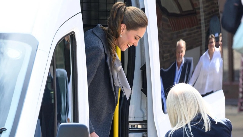 Princess Catherine leans in through the minibus door and talks with a passenger