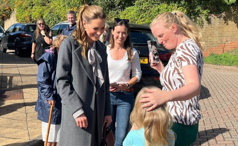 Princess Catherine in conversation with several women and a small child outside the village hall