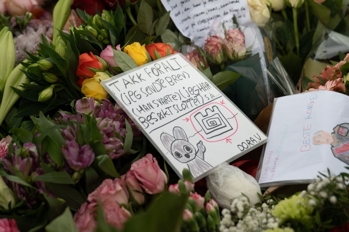 A child\u0027s drawing with the words TAKK FOR ALT lies among roses and bouquets on the Palace Square