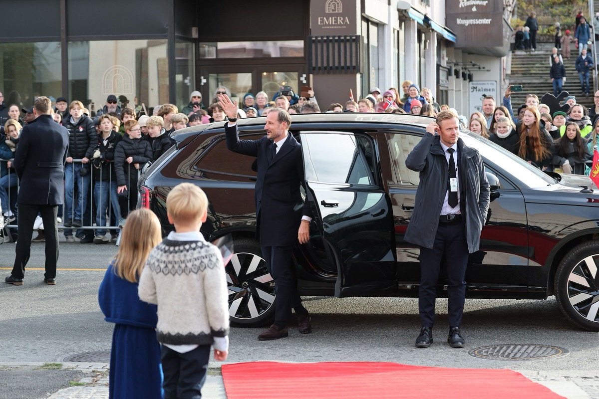 Kong Haakon kommer ut av bilen på den røde løperen i Narvik sentrum