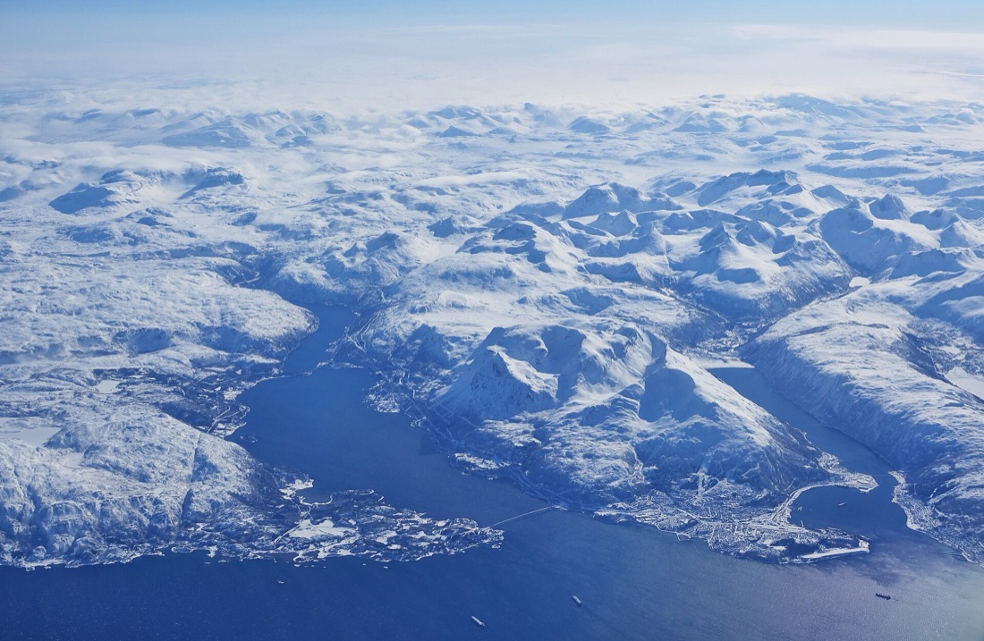 Narvik og Ofotfjorden sett fra lufta med snødekte fjell rundt