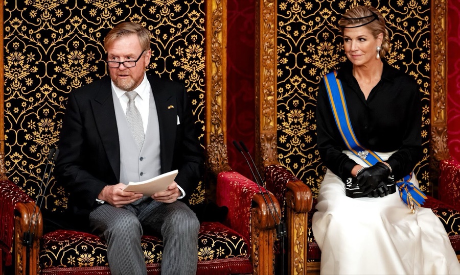 King Willem-Alexander reads from a script in a gilded chair, with Queen Máxima beside him