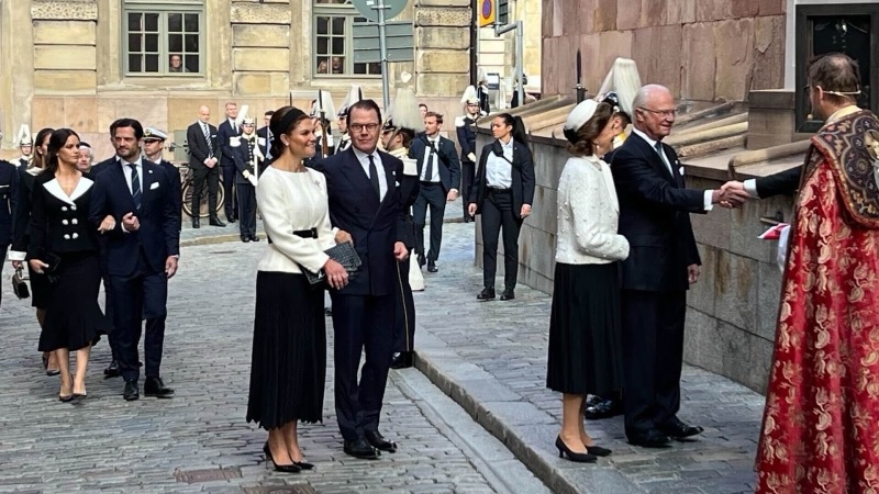 Kongefamilien ankommer Storkyrkan, der en prest i rød messehagel tar imot dem