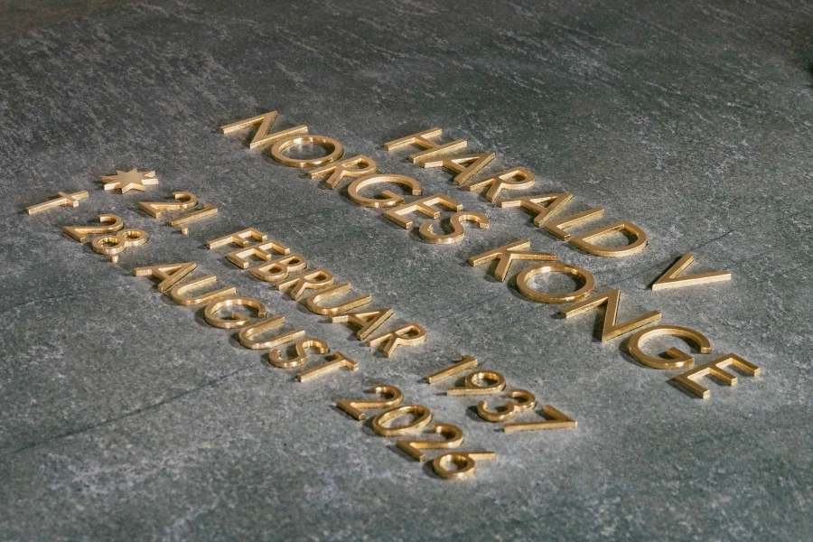 Gold-plated letters in the stone reading Harald V, King of Norway, with the dates of birth and death