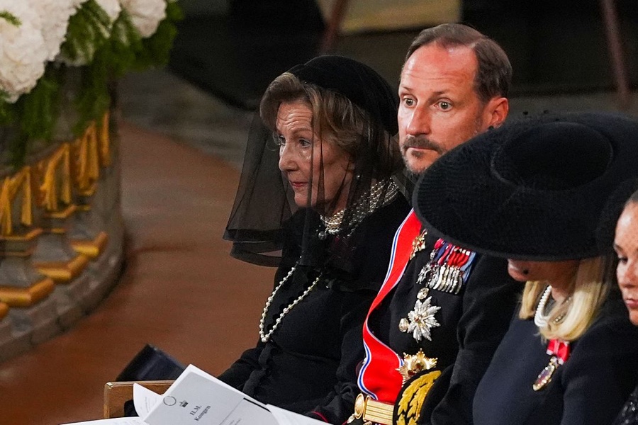 Close-up of Queen Sonja in a mourning veil and pearls beside King Haakon in full dress uniform with orders