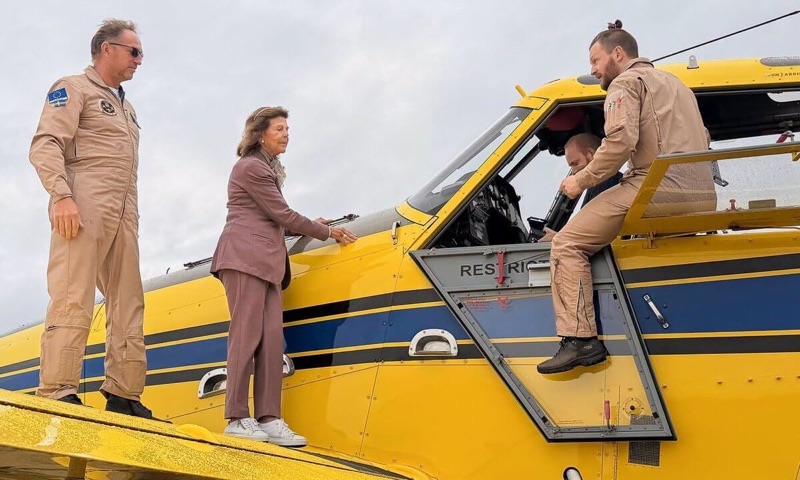 Dronning Silvia på vingen ser inn i cockpiten på flyet