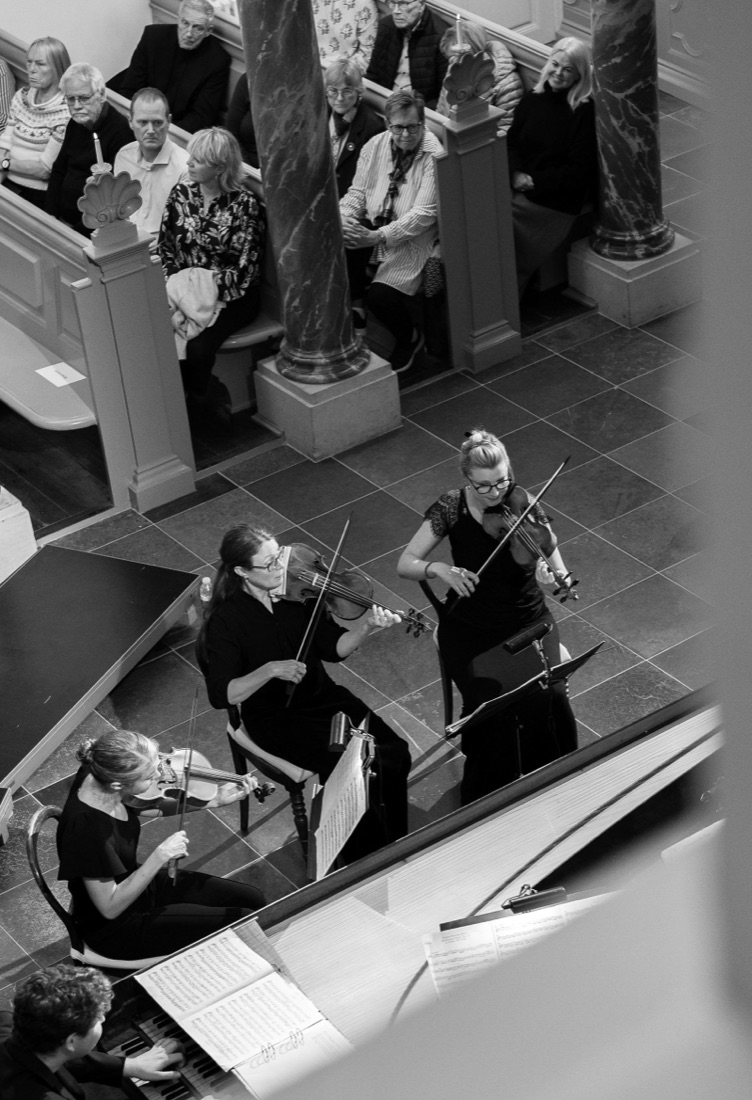 Musicians from Concerto Copenhagen playing baroque instruments in the chapel, seen from above