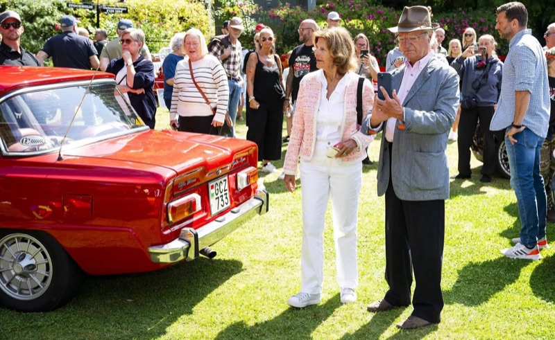 Kong Carl Gustaf fotograferer en rød Alfa Romeo med mobilen